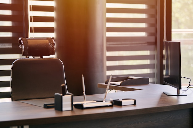 Lieu de travail de bureau. Lumière du soleil sur le lieu de travail pour le chef, le patron ou d’autres employés. Table et chaise confortable. Lumière à travers les stores semi-ouverts