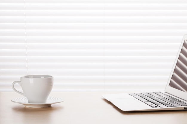 Lieu de travail de bureau avec ordinateur portable et tasse à café