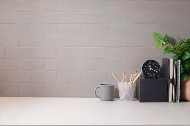 Lieu de travail confortable avec cadre photo, bloc-notes, tasse à café et plante d'intérieur Bureau à domicile Espace de copie pour votre texte