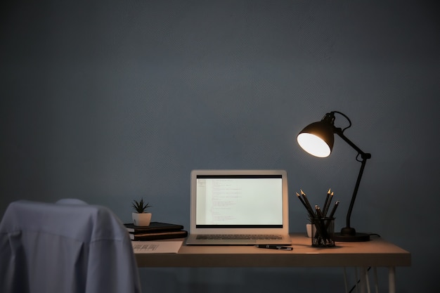 Lieu de travail confortable avec ordinateur portable sur le bureau à la maison