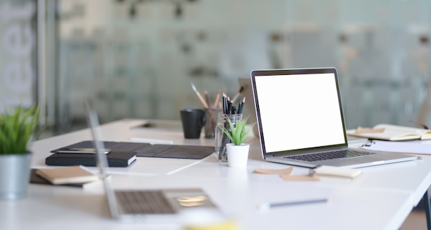 Lieu de travail du concepteur avec ordinateur portable à écran blanc ouvert