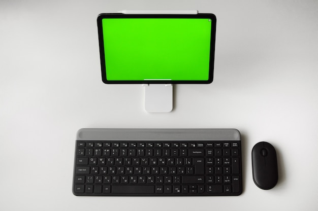 Photo lieu de travail à la maison avec la tablette sur table avec support et clavier et souris