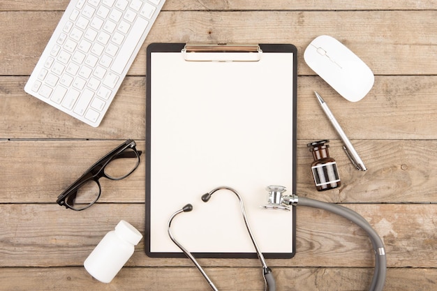 Lieu de travail d'un médecin Stéthoscope presse-papiers pilules et autres trucs sur un bureau en bois