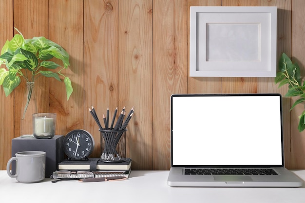 Lieu de travail simple avec ordinateur portable tasse à café plante d'intérieur et papeterie sur tableau blanc