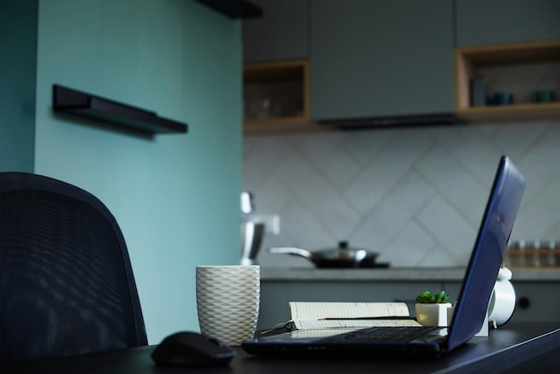 Lieu de travail avec table et ordinateur portable au bureau à domicile de la cuisine et concept de travail à distance