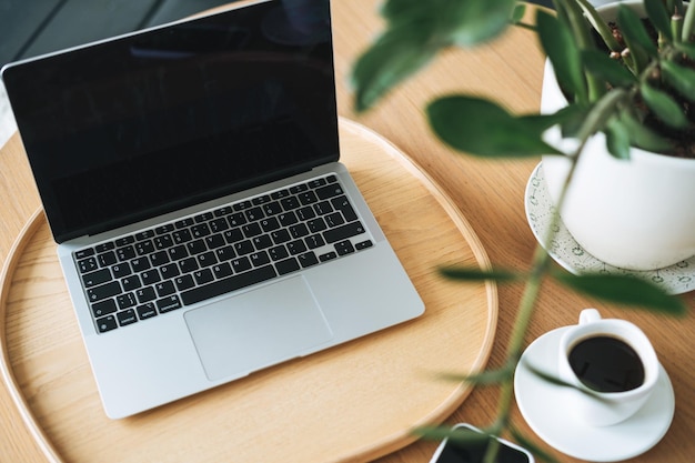 Lieu de travail avec une tasse de café ordinateur portable ouvert sur une table en bois dans la chambre