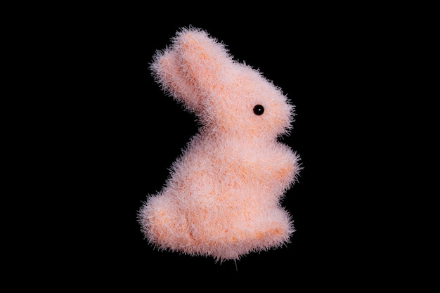 Lièvre rose jouet isolé sur fond noir. lapin moelleux. Pâques. photo de haute qualité