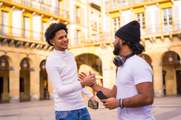 Lifestyle, deux amis latinos noirs agitant alors qu'ils se rencontrent dans la rue