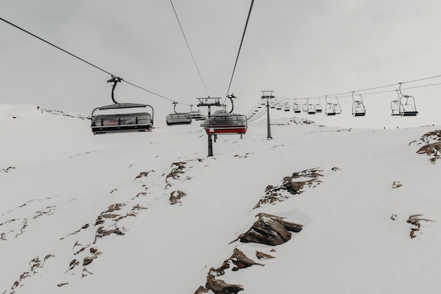 Photo lift de ski sur des montagnes couvertes de neige contre le ciel