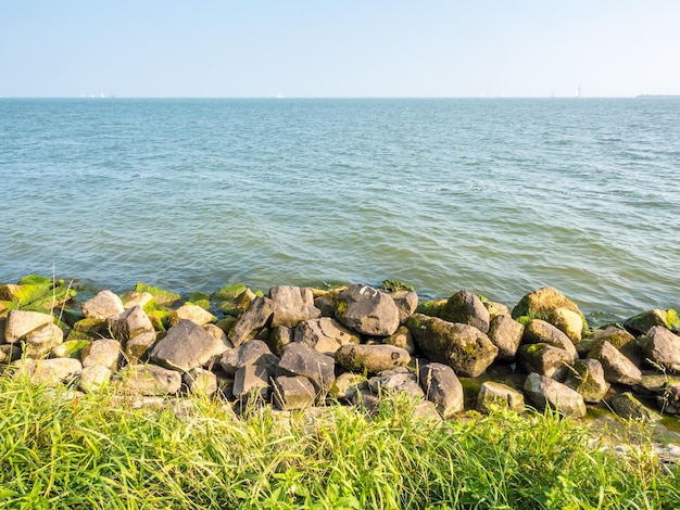 Ligne de côte et plage avec vue sur la mer à Volendam, Pays-Bas, sous ciel bleu