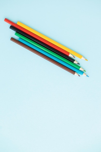 Ligne de crayons de couleur avec vague sur fond bleu