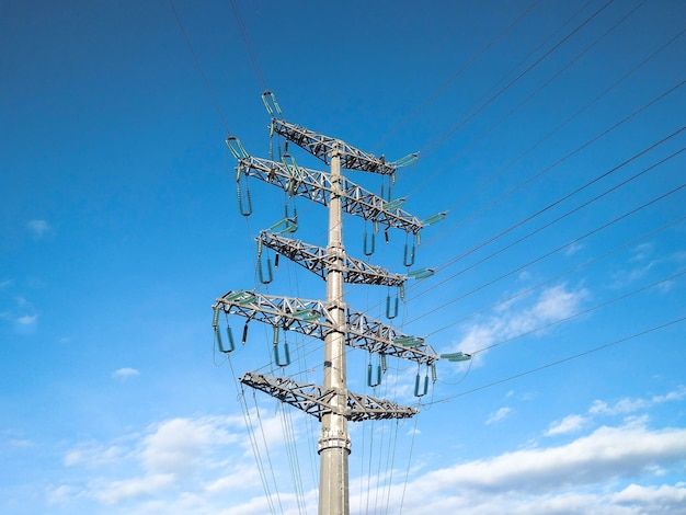 Ligne électrique aérienne avec des fils électriques au ciel bleu