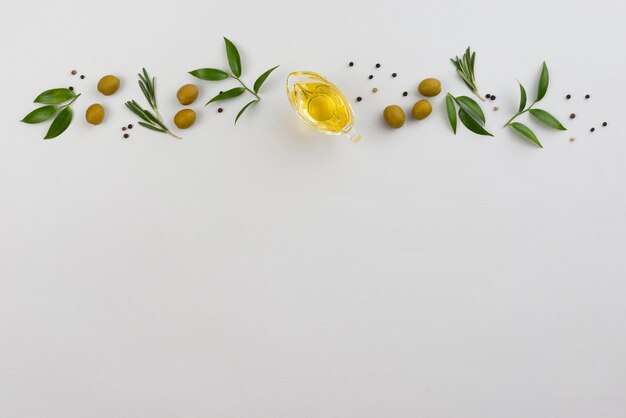 Ligne de feuilles et d'olives avec une tasse d'huile