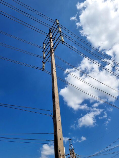 Ligne de transmission électrique à haute tension sur des nuages sur fond bleu