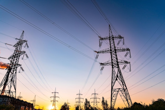 Lignes électriques au fond du coucher de soleil Montagne de pôle haute tension le soir Concept de coucher de soleil super cool de ligne à haute tension