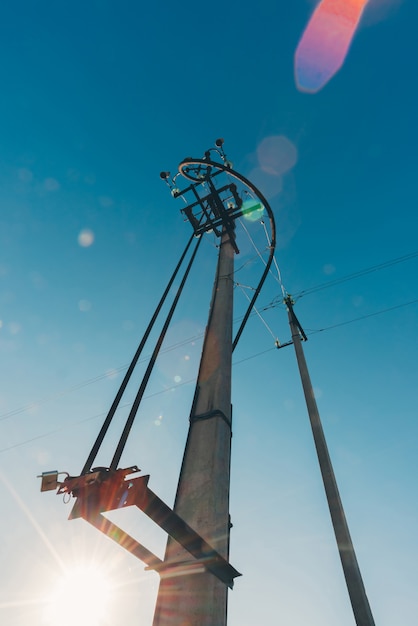 Lignes électriques de gros plan de ciel bleu. Moyeu électrique sur poteau. Matériel électrique avec espace copie. Fils de haute tension dans le ciel. L'industrie de l'électricité.