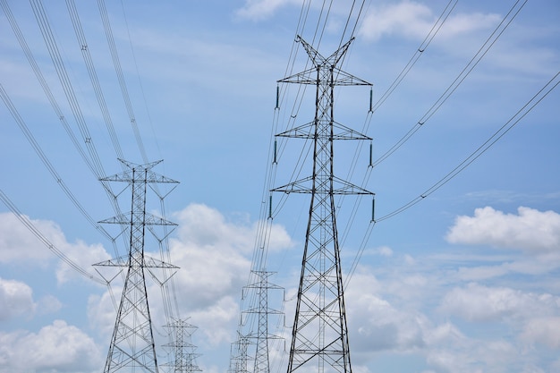 Lignes électriques haute tension sur des pylônes dans un ciel bleu