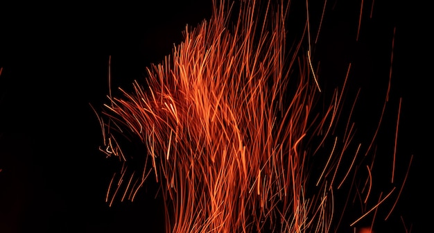 Lignes d'étincelle de flamme de feu rayures dans le ciel nocturne sombre feu de joie isolé