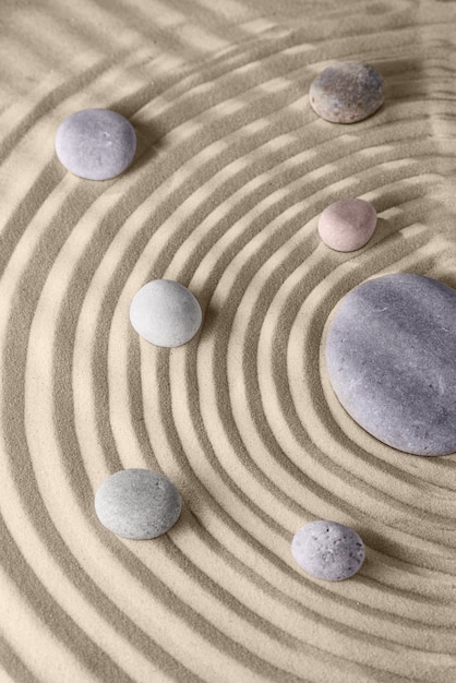 Lignes lisses sur le sable et les pierres rondes