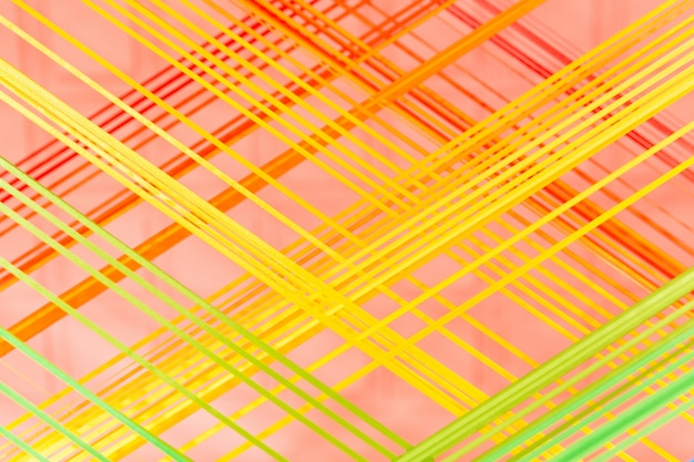 Lignes textiles jaunes et orange sur fond rose. Détail créatif de l&#39;intérieur de la pièce