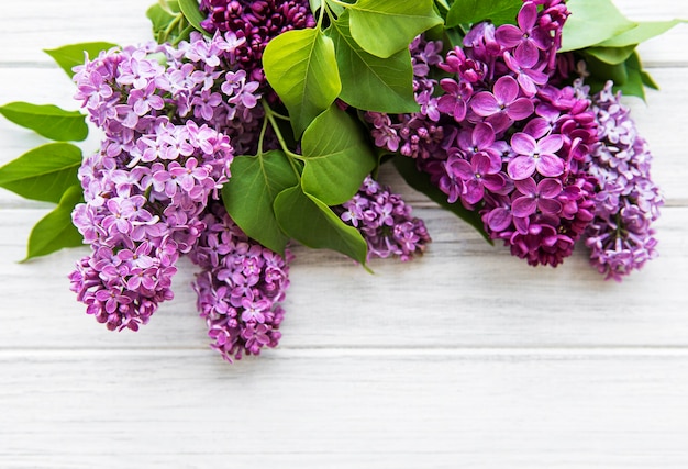 Lilas dans un style plat sur une surface en bois blanche