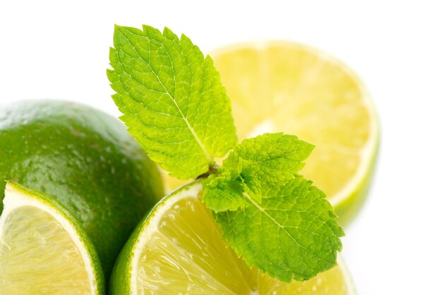 Limes fraîches entières et tranchées à la menthe sur DOF blanc