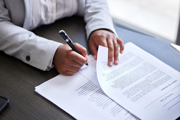 Éliminons la paperasse Photo recadrée d'une femme d'affaires signant des documents dans un bureau