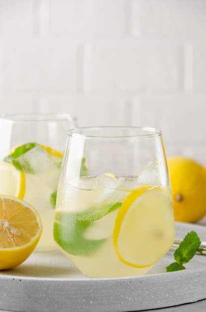 Limonade au citron, menthe et glace dans un verre avec paille en métal