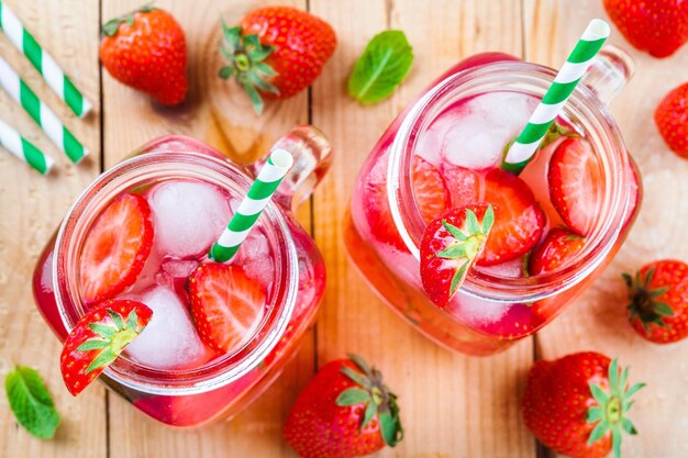 Limonade aux fraises avec de la glace dans un pot Mason sur une table en bois