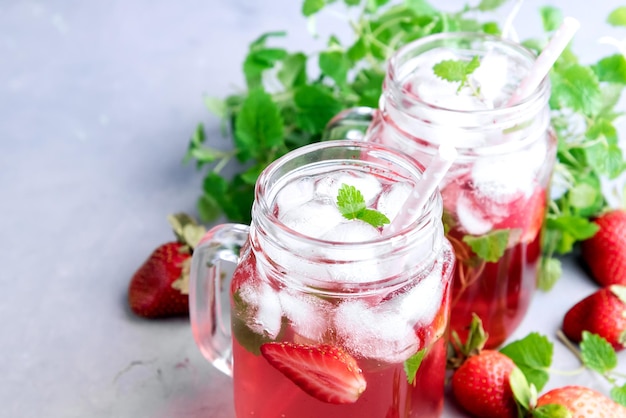 Limonade aux fraises avec glace et menthe dans des bocaux en verre