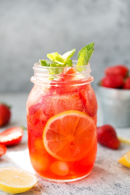Limonade aux fraises maison avec de la glace dans un bocal, cocktail d'été froid, mise au point sélective