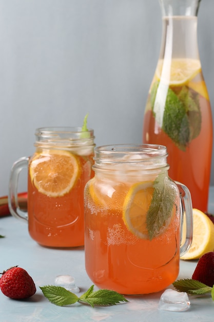 Limonade aux fraises, menthe, citron et glace sur table bleu clair