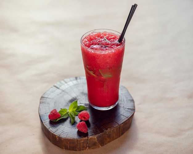 Limonade aux framboises sur un support en bois dans un bécher en verre