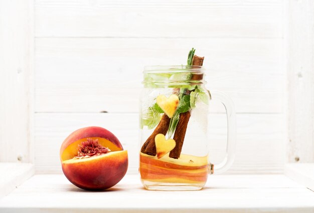 Limonade aux fruits d'été dans un bocal en verre sur une table en bois clair