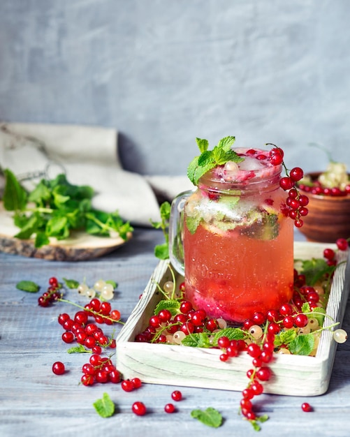 Limonade aux groseilles rouges et à la menthe Servir du jus avec de la glace et de la menthe Une récolte de baies fraîches