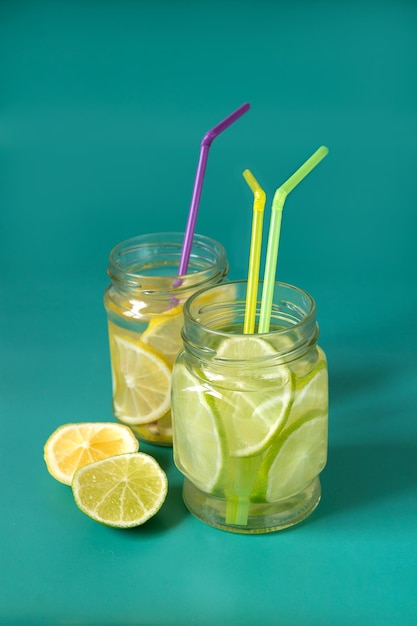 Limonade citron vert et citron dans des bocaux en verre sur fond vert