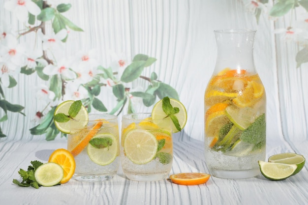 limonade froide aux agrumes avec glace, citron, menthe, citron vert et orange