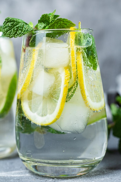 Limonade froide à la menthe, citron et citron vert dans un verre. Préparation de limonade