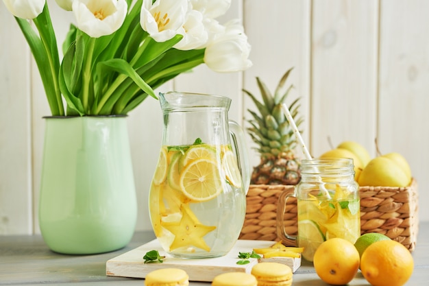 Limonade, macarons sucrés, fruits et fleurs de tulipes