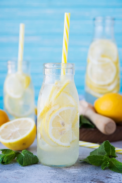 Limonade maison aux citrons et menthe dans des bouteilles en verre