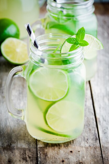 Limonade maison à la menthe citron vert dans un pot Mason sur une table rustique en bois