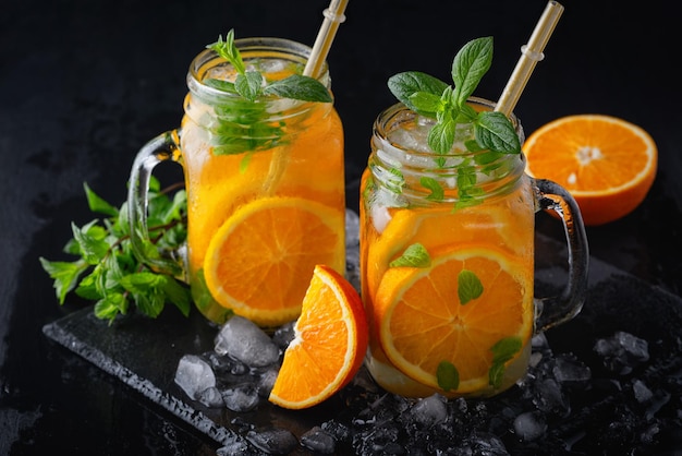 Limonade orange d'été froide à la menthe et à la glace dans un verre