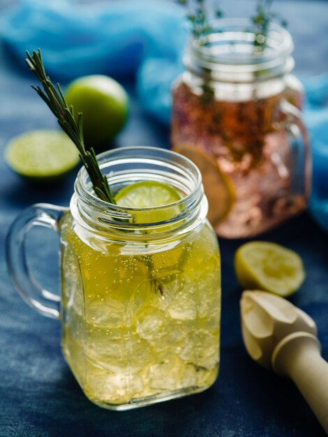 Limonade pétillante faite maison avec citron, romarin et thym dans un bocal Mason,