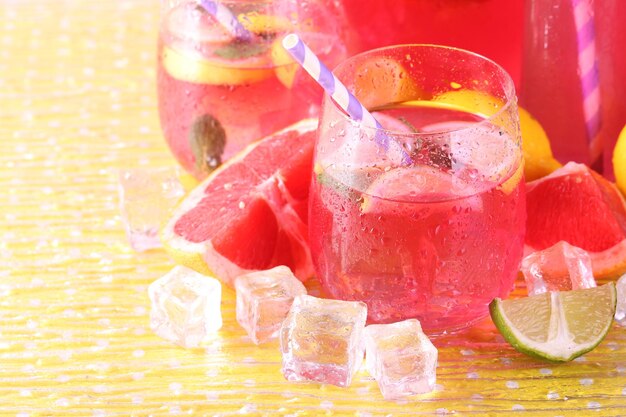 Photo limonade rose dans des verres et un pichet sur fond clair