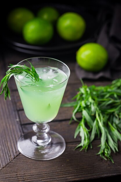 Limonade vert vif à l'estragon et citron vert boisson rafraîchissante avec de la glace sur fond noir