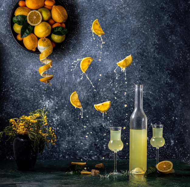 Limoncello en bouteille et deux grappas verre à vin citron frais en assiette