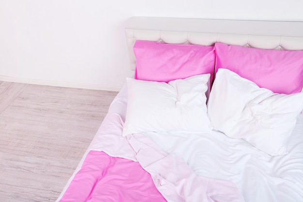 Linge rose froissé sur le lit