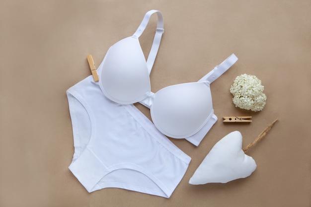 Lingerie en coton blanc. lingerie bio pour femmes sur fond marron. Vue de dessus d'un tissu doux naturel