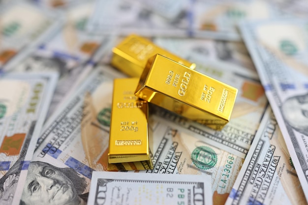 Lingots d'or sur fond de gros plan de billets en dollars américains