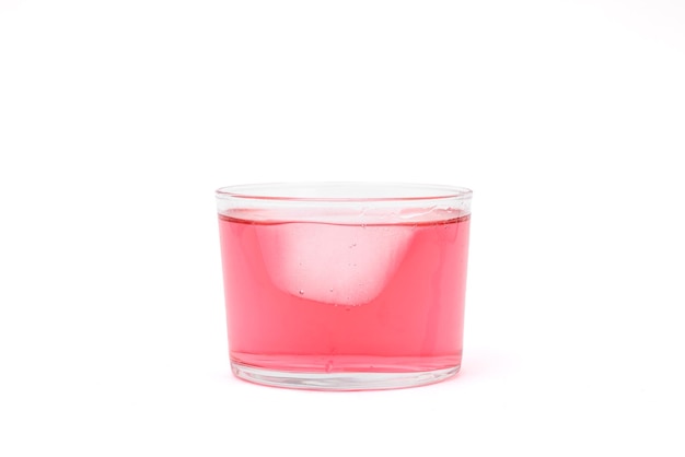 Liqueur rose avec de la glace dans un verre en cristal.